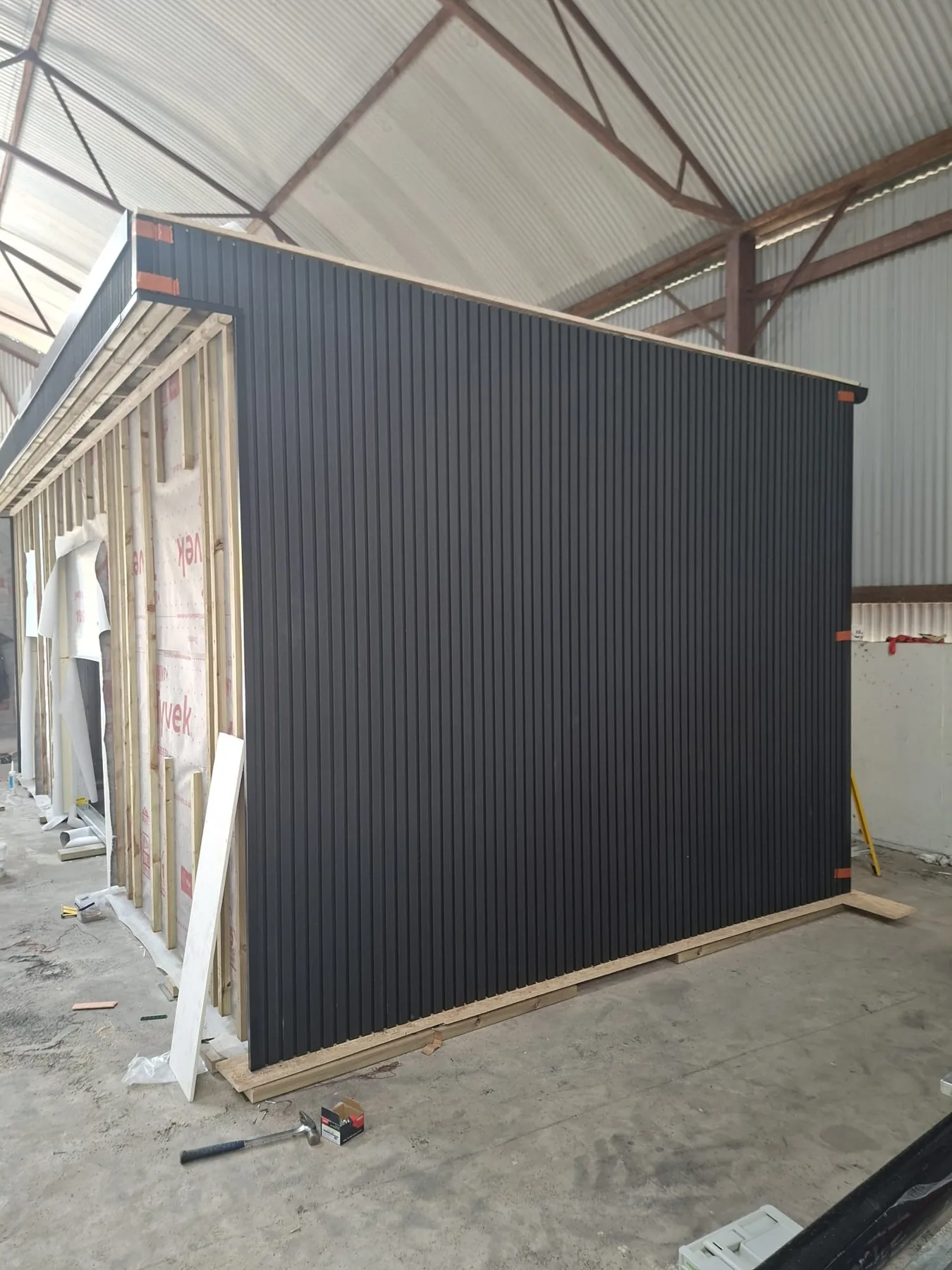 Dark vertical exterior cladding on the garden room